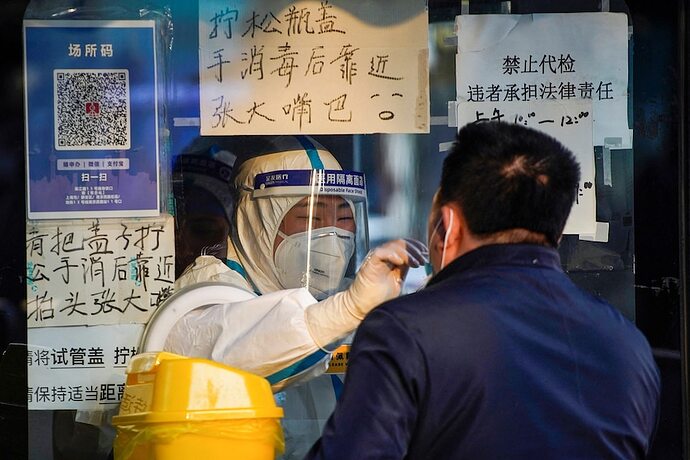 在中国，一名穿着防护服的医务人员正在收集一名男子的棉签检测样本。