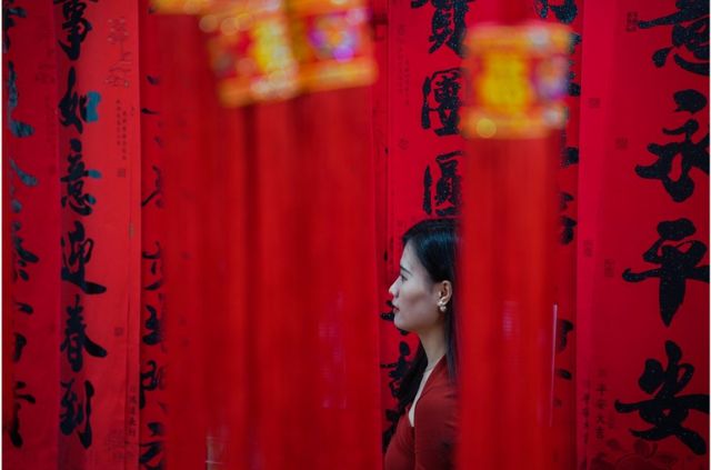 广西南宁一名妇女在即将到来的中国农历新年前购买红灯笼和对联装饰
